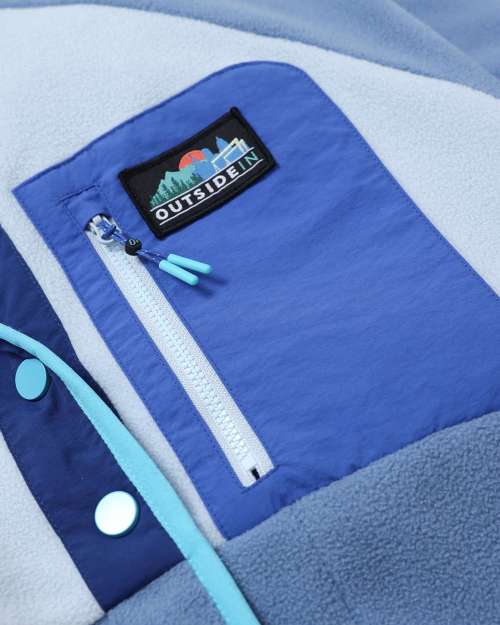 Lightweight fleece jacket detail with OutsideIn chest patch and white zipper with light blue cord tabs