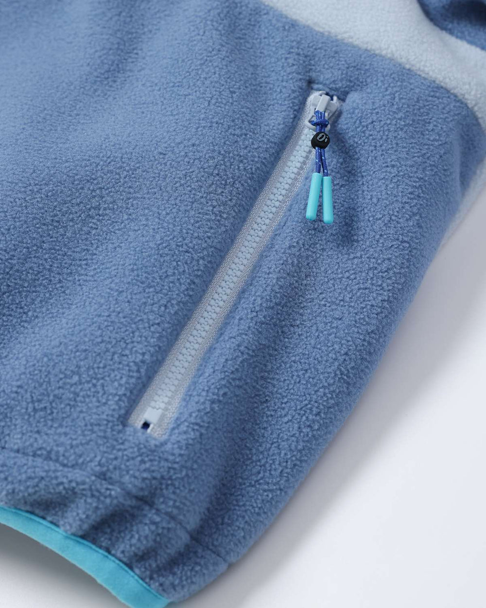 Lightweight fleece jacket side seam with white zipper and light blue drawcord end tabs