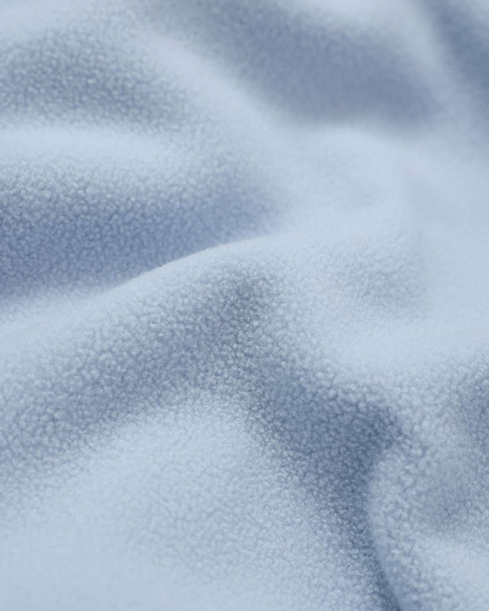 Light blue lightweight fleece fabric texture close-up, soft plush surface