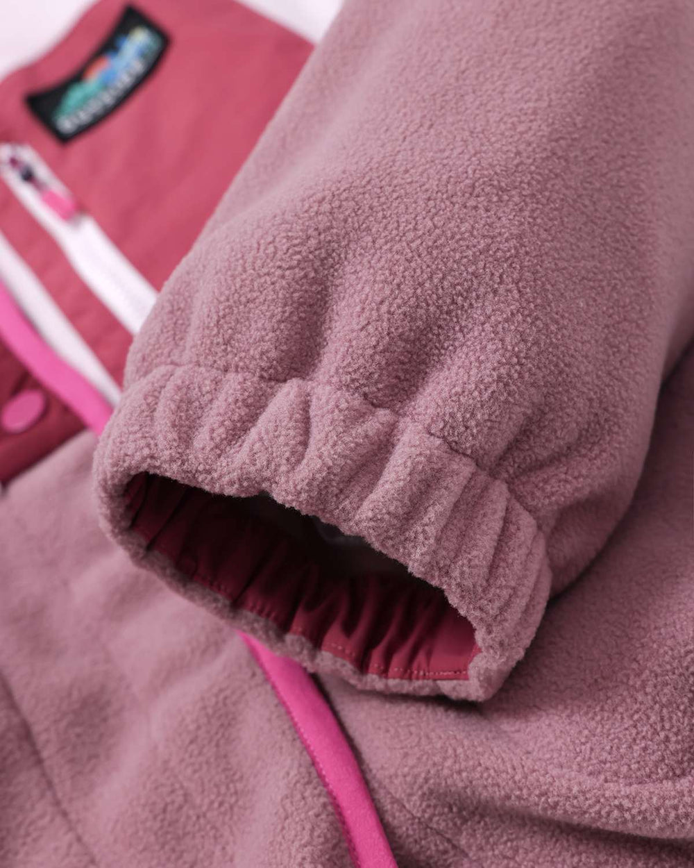 Elastic-cuff fleece sleeve with pink trim and snap placket edge