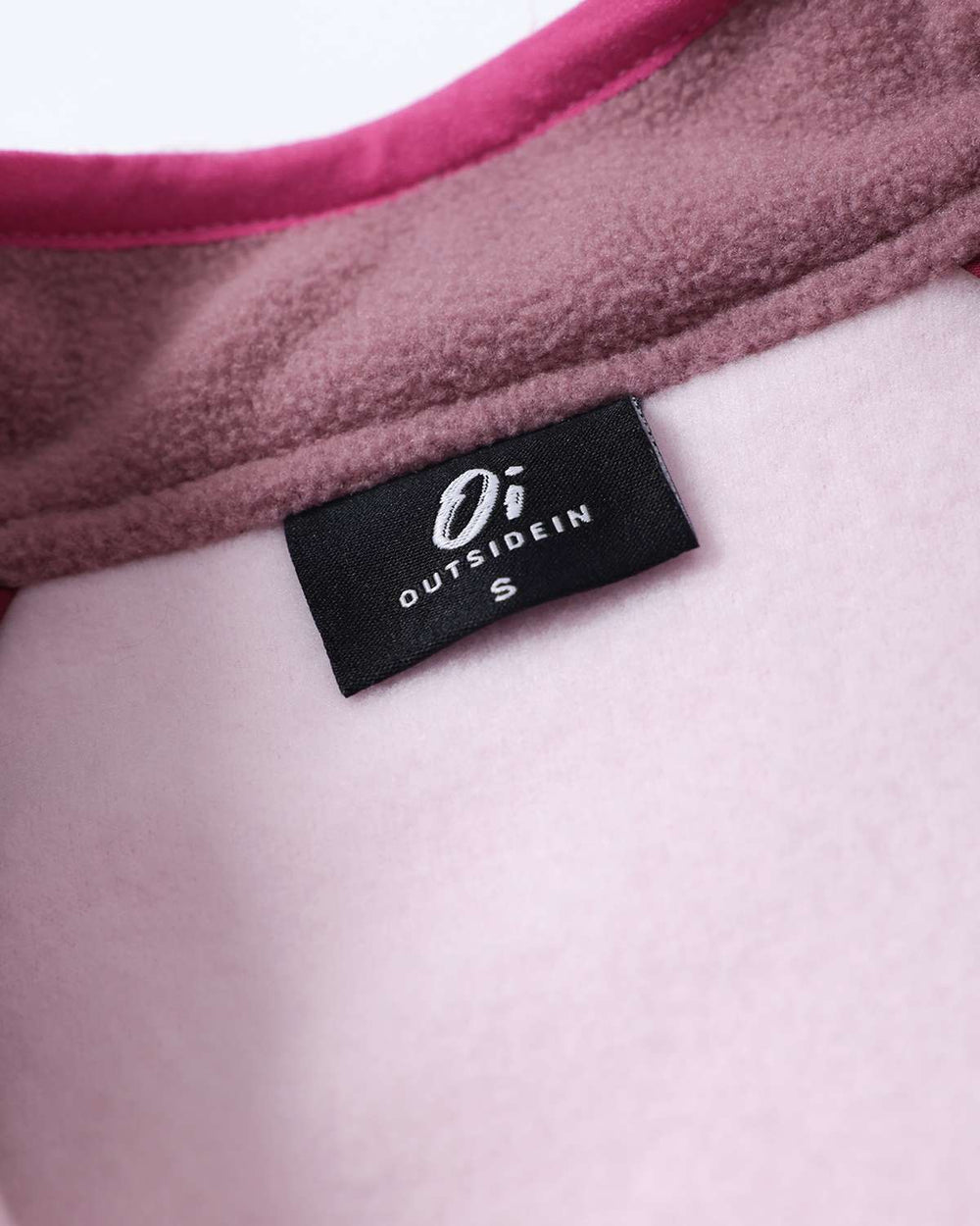 Logo neck label on pink-trim fleece jacket with snap button placket