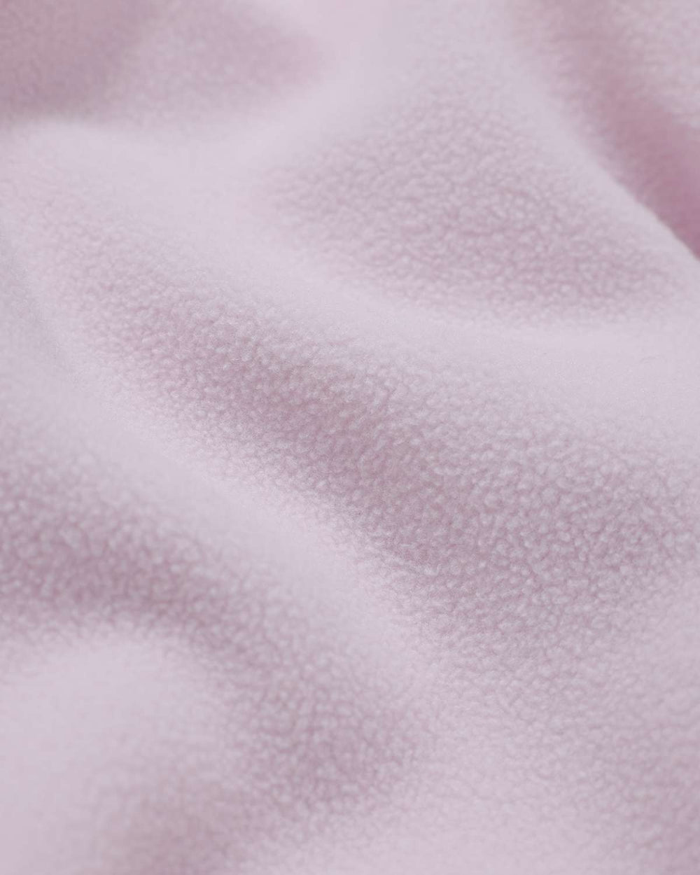 Light mauve fleece fabric texture close-up with soft sherpa-like surface