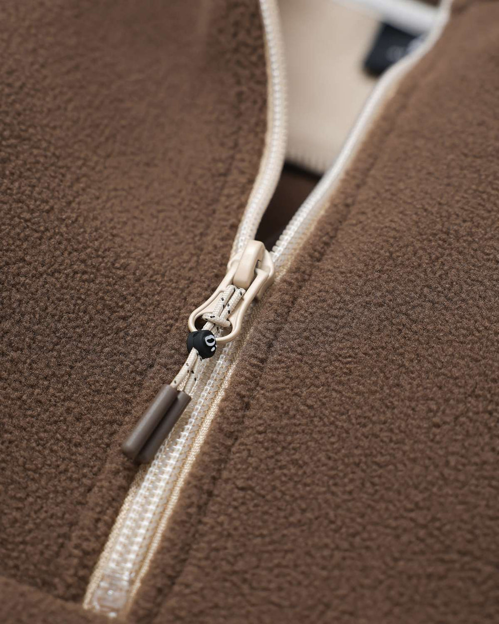 Brown fleece half-zip with contrast cream zipper tape and metal zipper pull