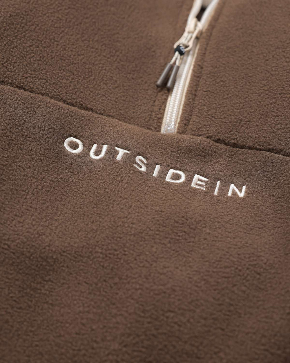 Brown fleece chest with OutsideIn logo text and contrast cream zipper detail