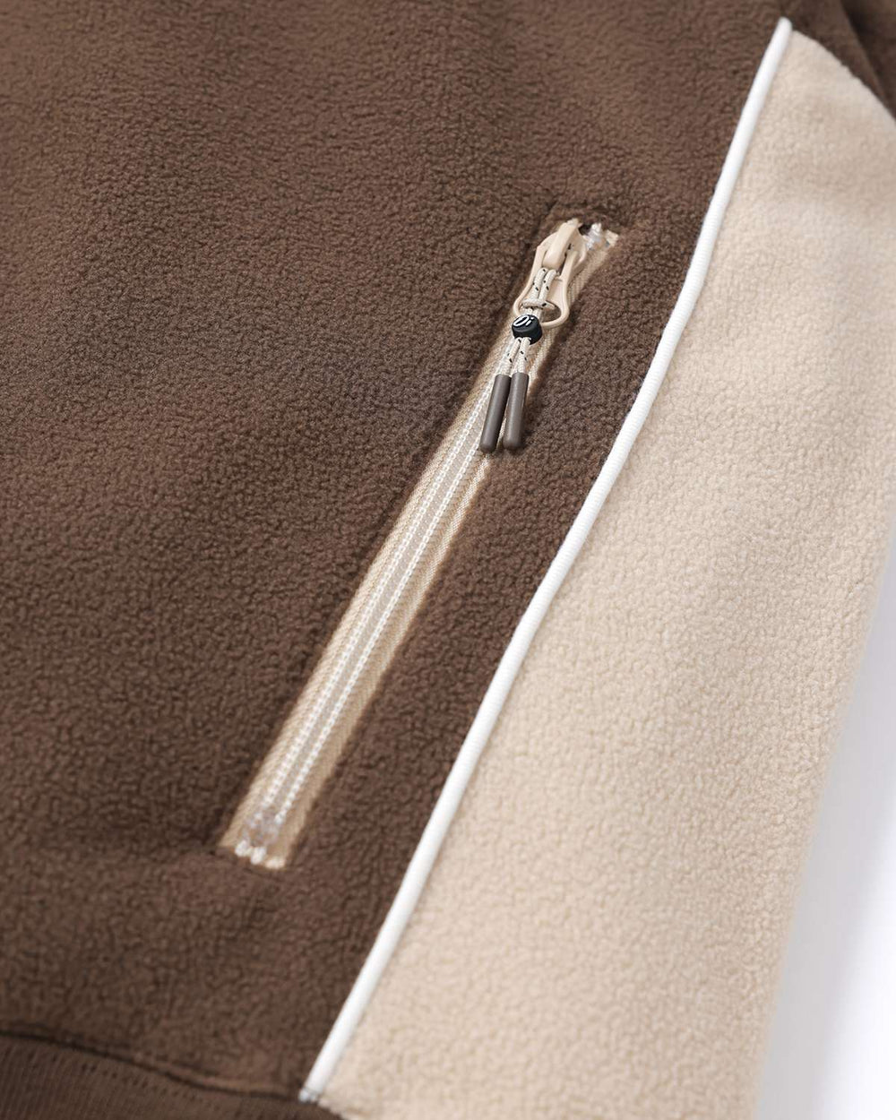 Brown fleece side view showing half-zip with cream zipper tape and contrast panel
