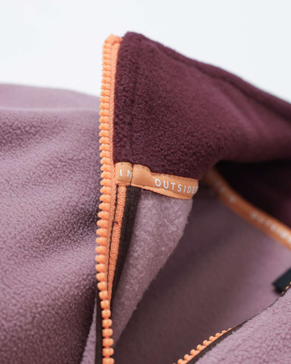 Quarter-zip fleece with orange-gold zipper track and contrast fleece-lined collar