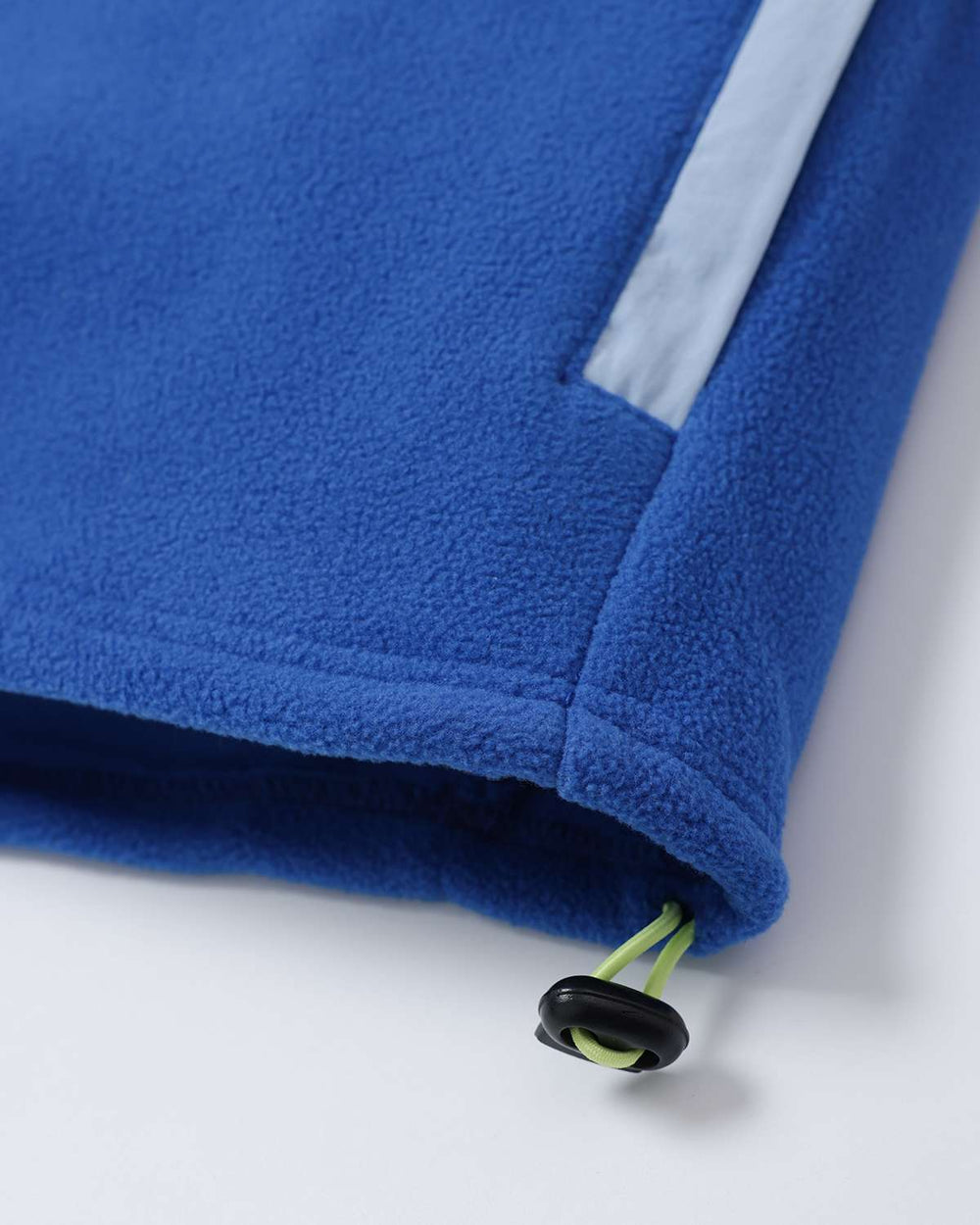 Microfleece hem with blue fabric base and visible lime zipper pull