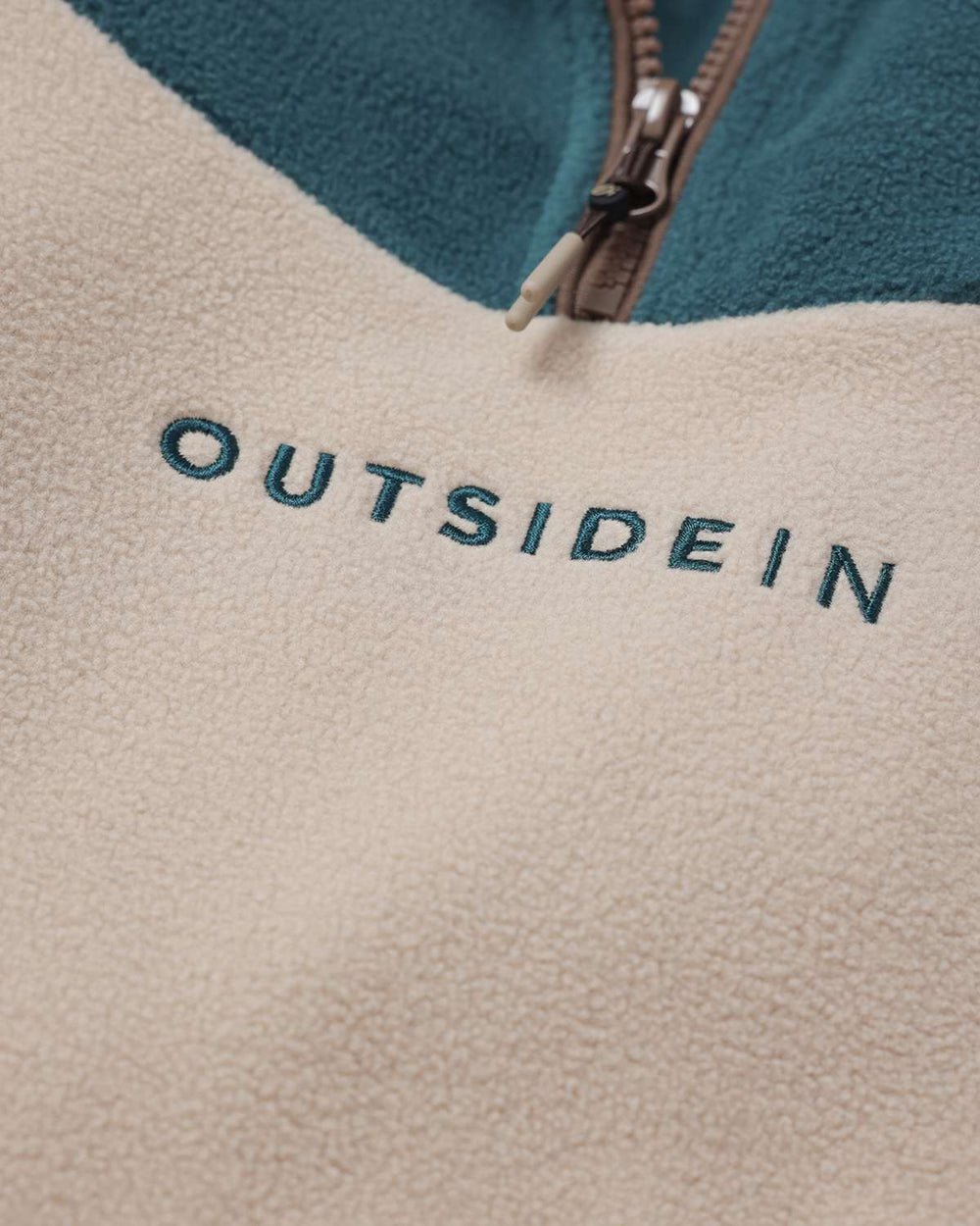 OutsideIn logo on cream fleece panel with teal upper yoke and brown lower body