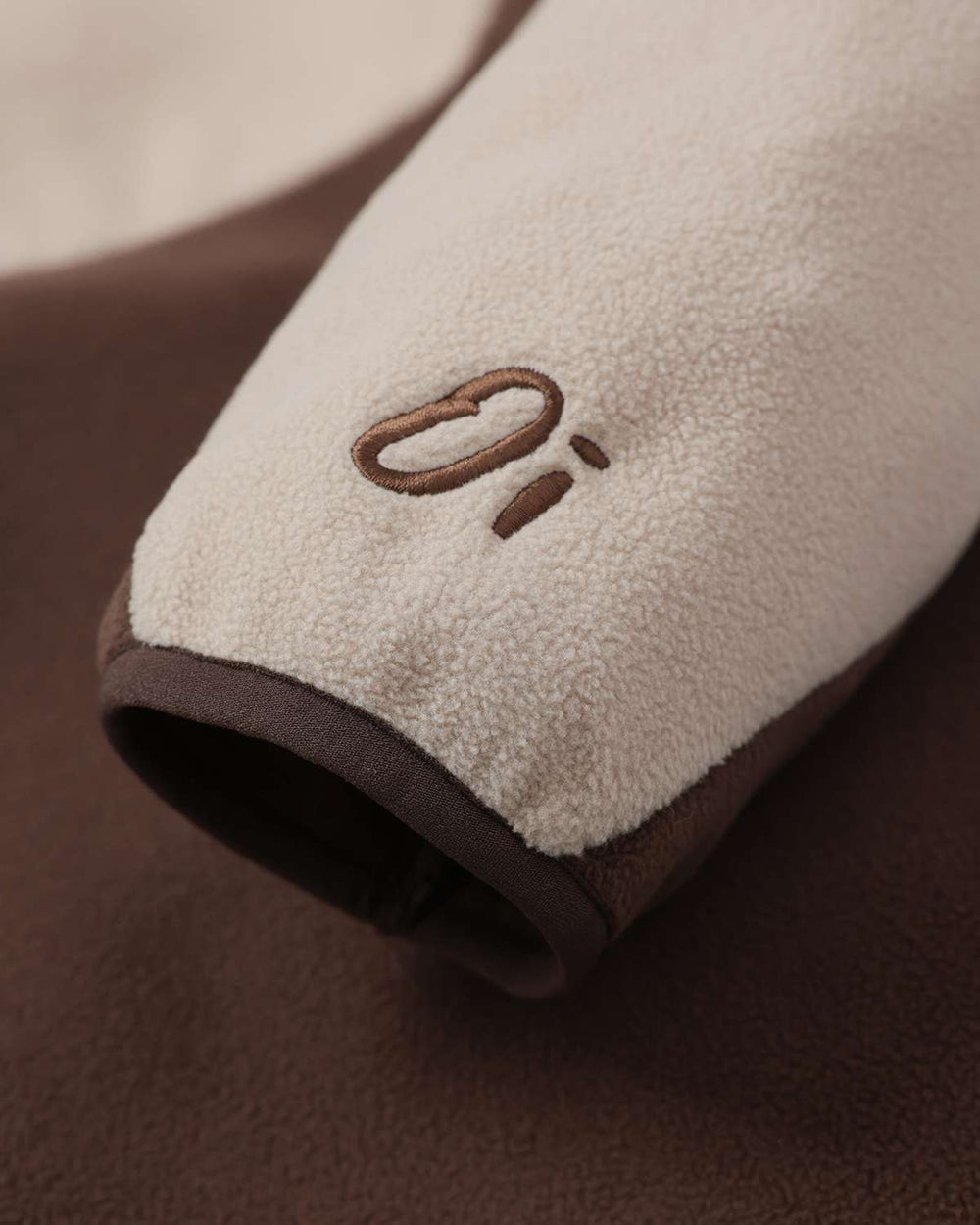 Fleece sleeve cuff with stitched logo detail cream and brown color-block design