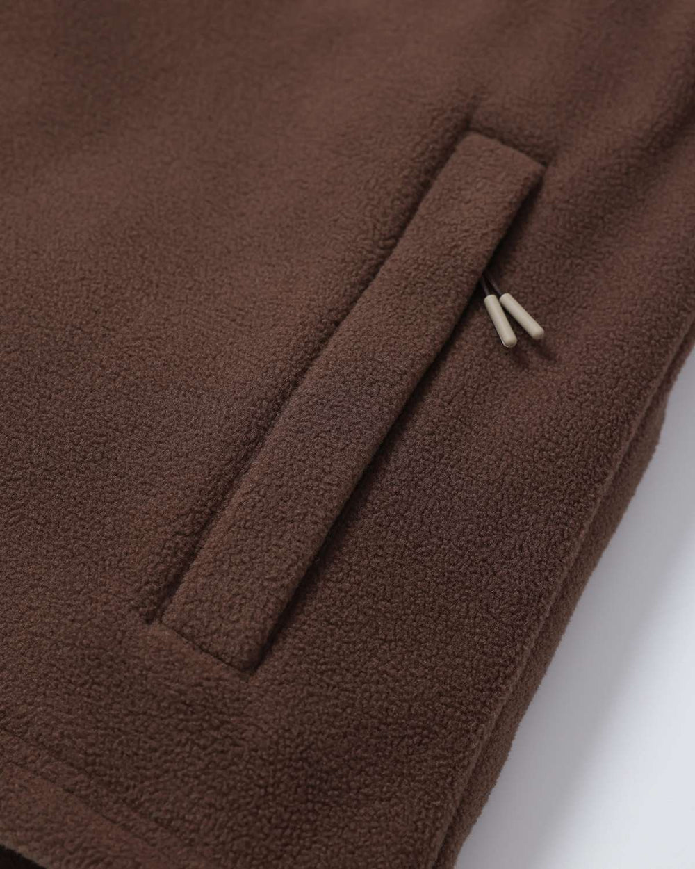 Brown fleece jacket with stitched pocket opening and small branded snap tab