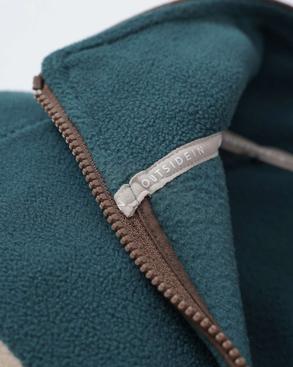 Teal fleece inner collar with brown zipper tape and OutsideIn logo label
