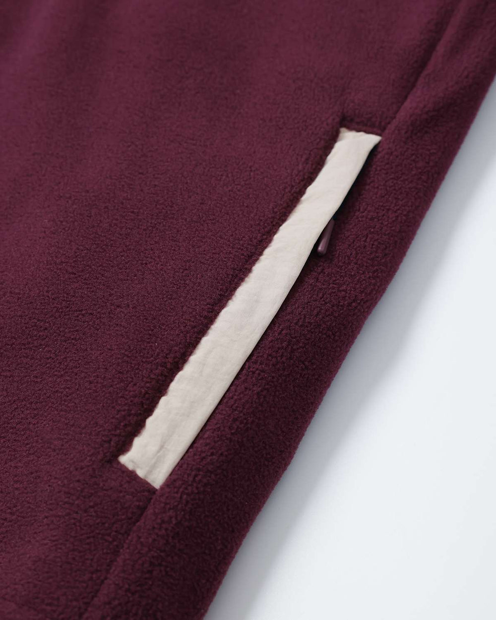 Maroon microfleece panel with white pocket opening detail and contrast trim