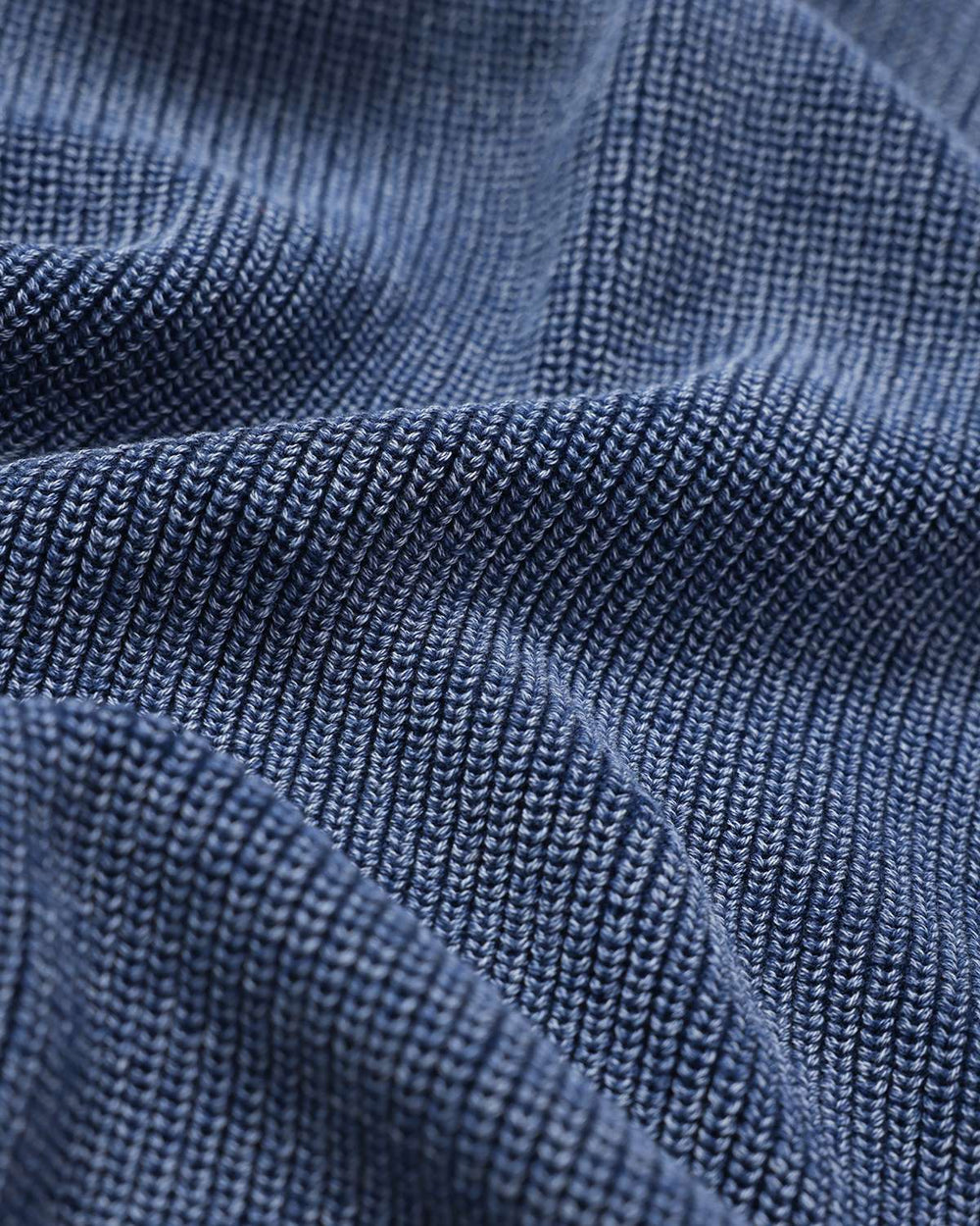 Blue rib knit sweater fabric close-up with textured stitch lines