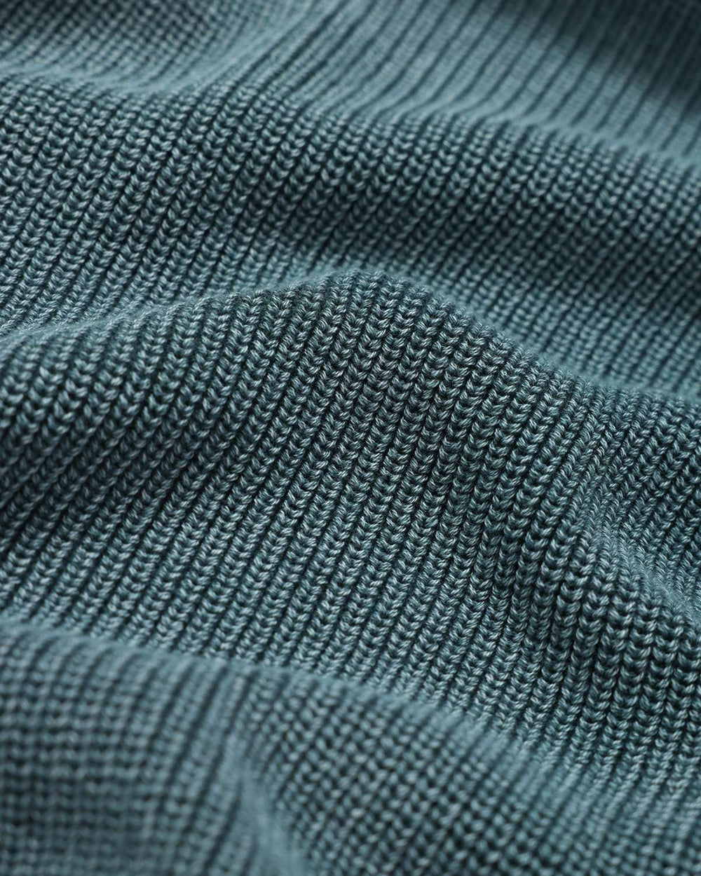 Fern green rib knit sweater fabric texture close-up, fine vertical ribbing