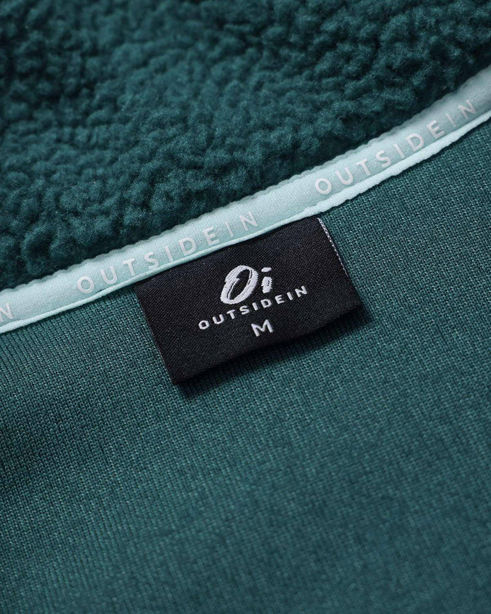 Evergreen borg fleece tag with OutsideIn branding on the side seam