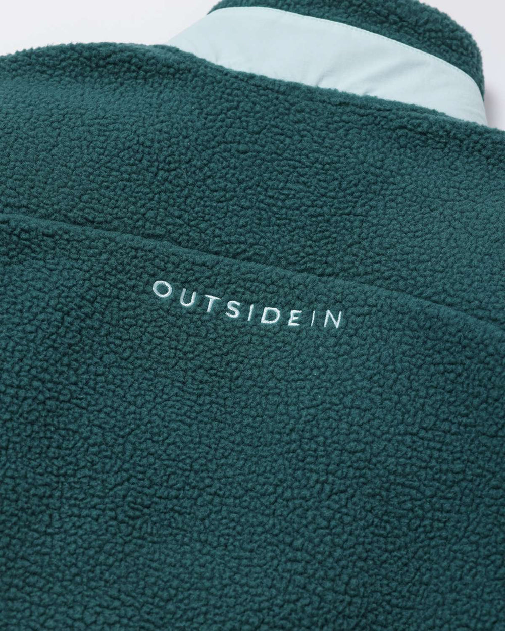 Evergreen borg fleece back with OutsideIn lettering near the shoulder