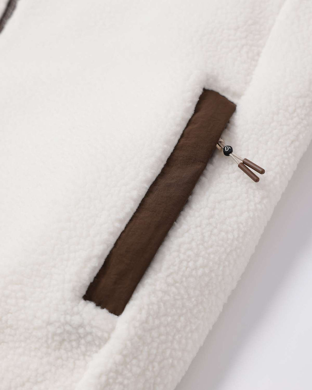 Fleece full-zip jacket sleeve opening with brown inner placket and metal zip pull