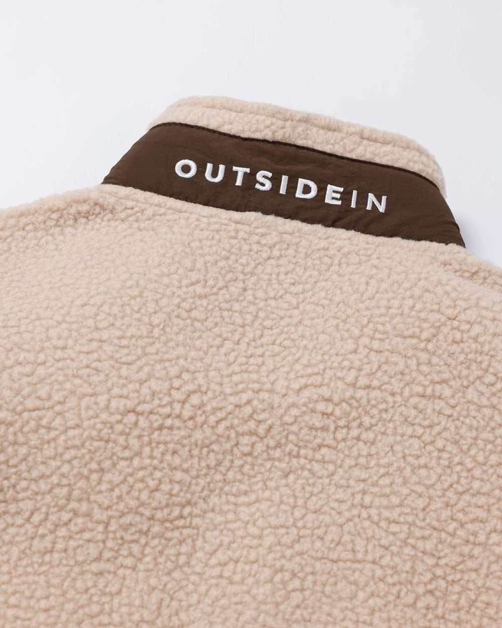 Fleece full-zip jacket back collar band with OutsideIn text logo in white on brown