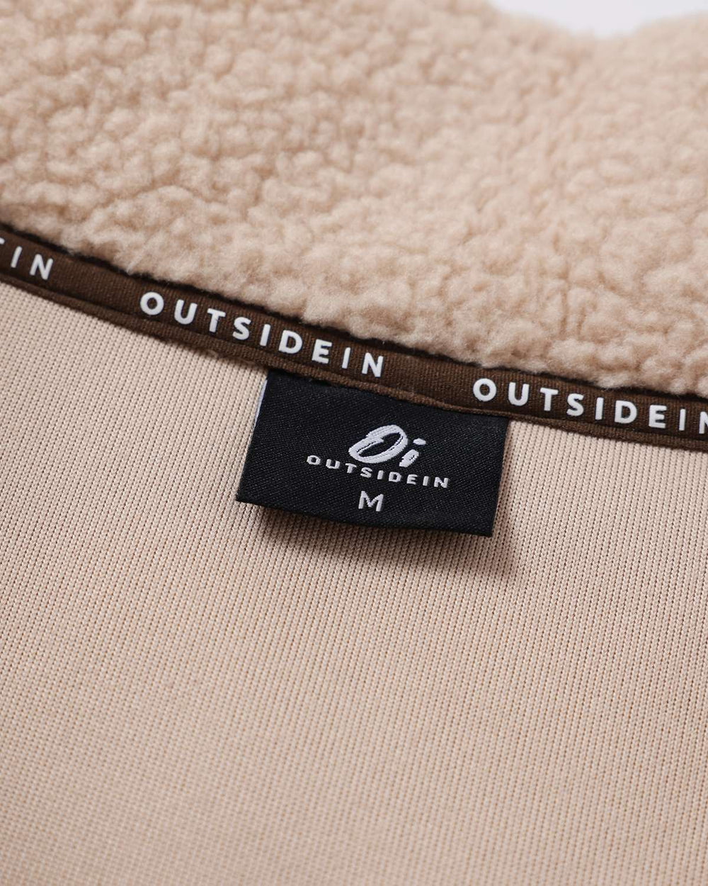 Fleece full-zip jacket inside tag label near collar band with OutsideIn branding