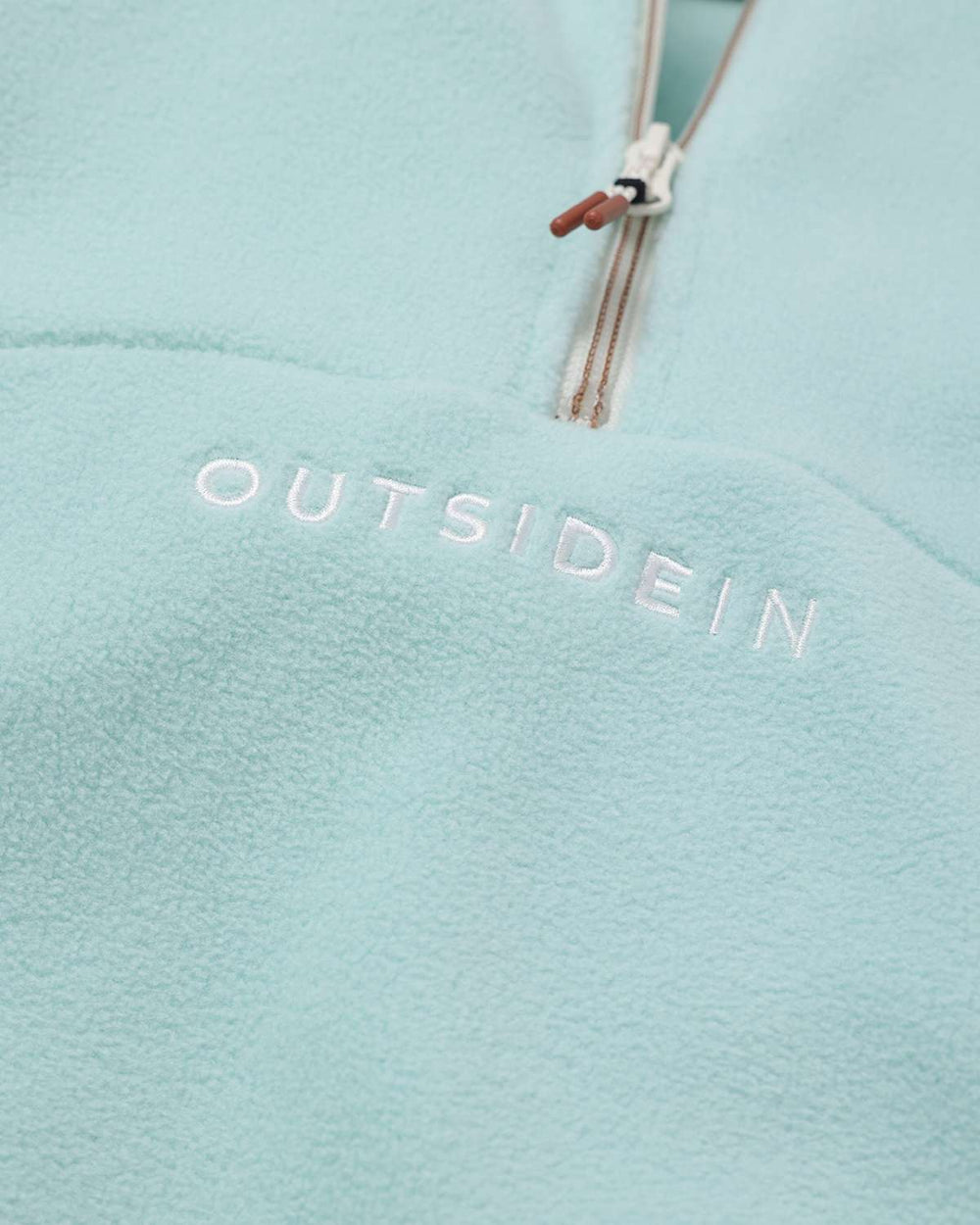 Light teal fleece sports top with OutsideIn logo on center chest