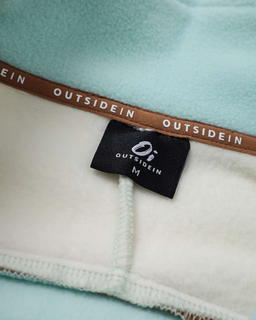 Inside view of fleece neck label and stitching along the seam with zipper placket