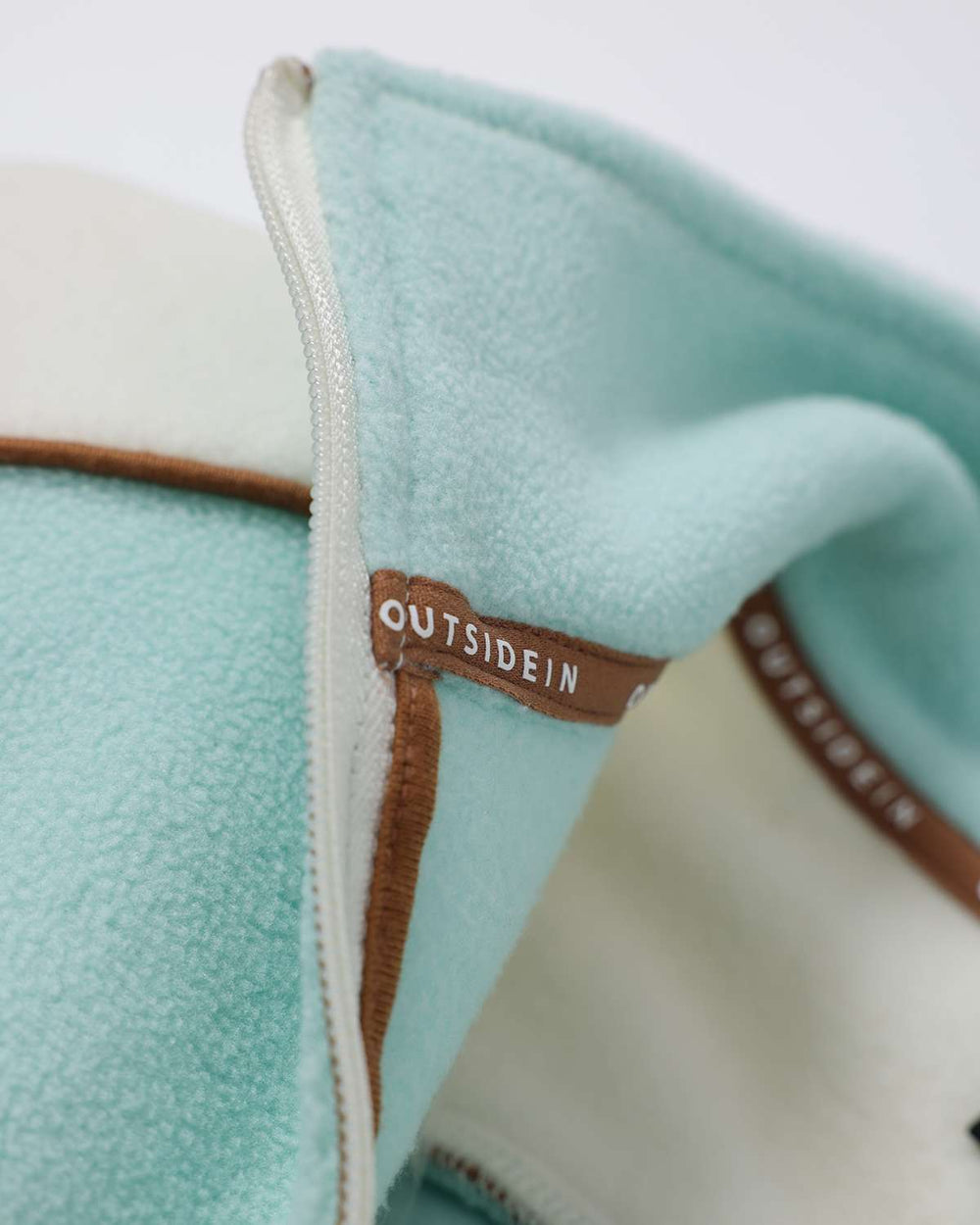 Light teal fleece collar edge with brown piping and OutsideIn printed strap