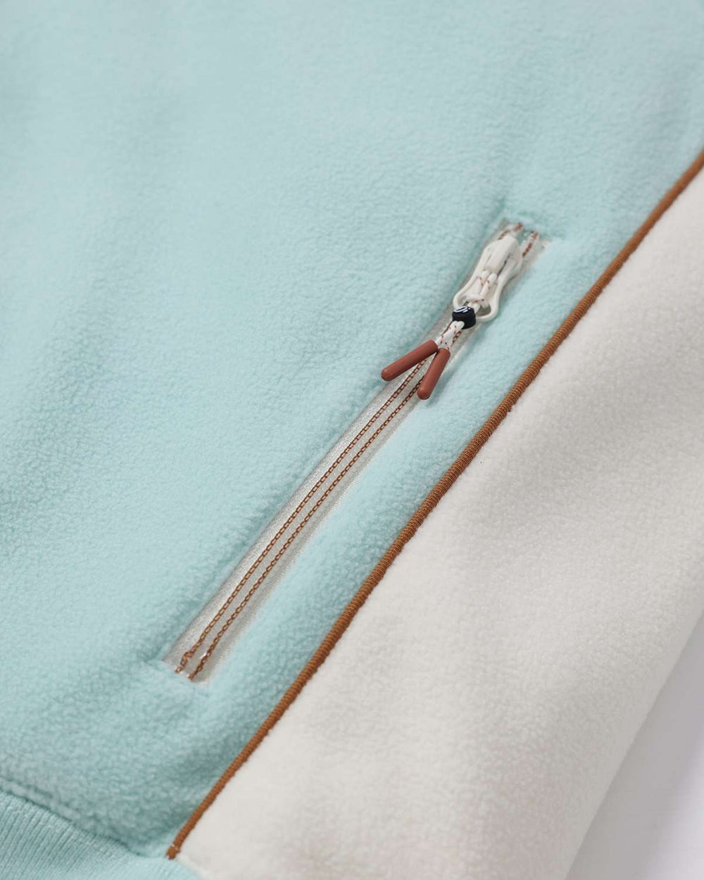 Light teal fleece quarter-zip with brown trim and visible zipper seam detail