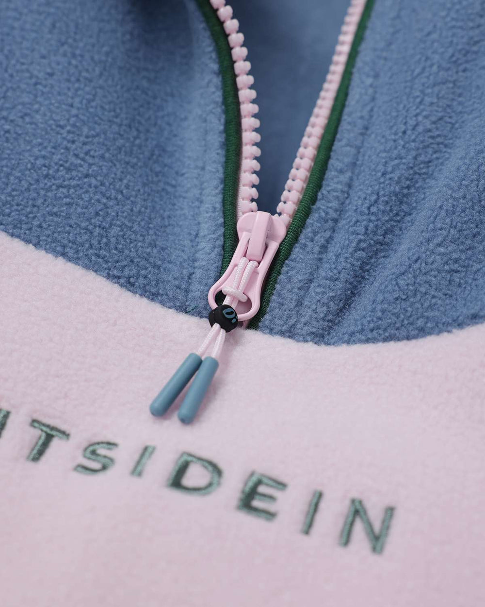 Fleece quarter-zip with pink zipper pull and embroidered brand text on light panel