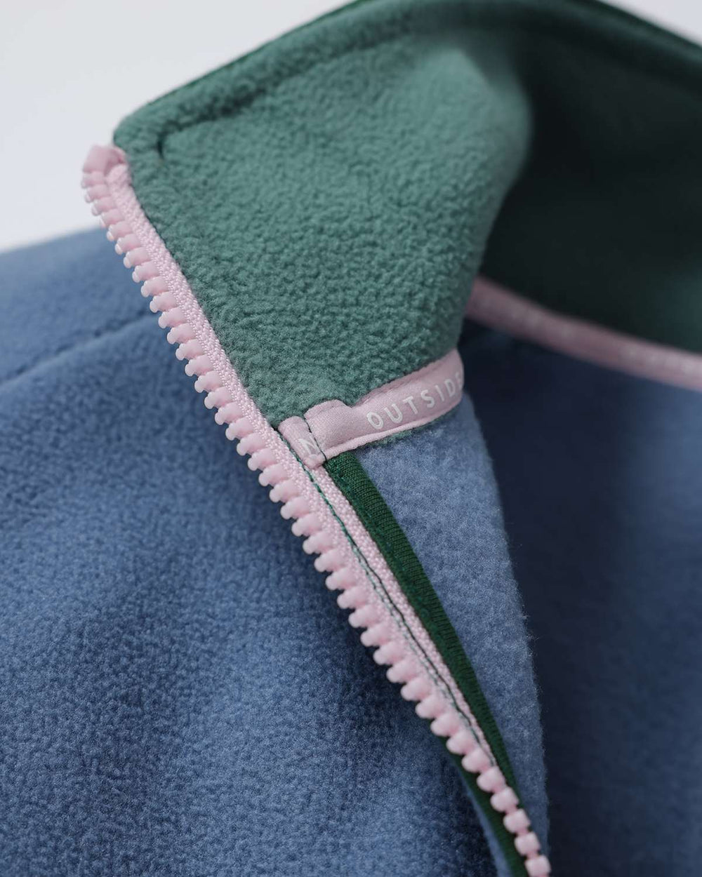 Fleece quarter-zip inner collar detail, green fleece with pink zipper trim and blue edge