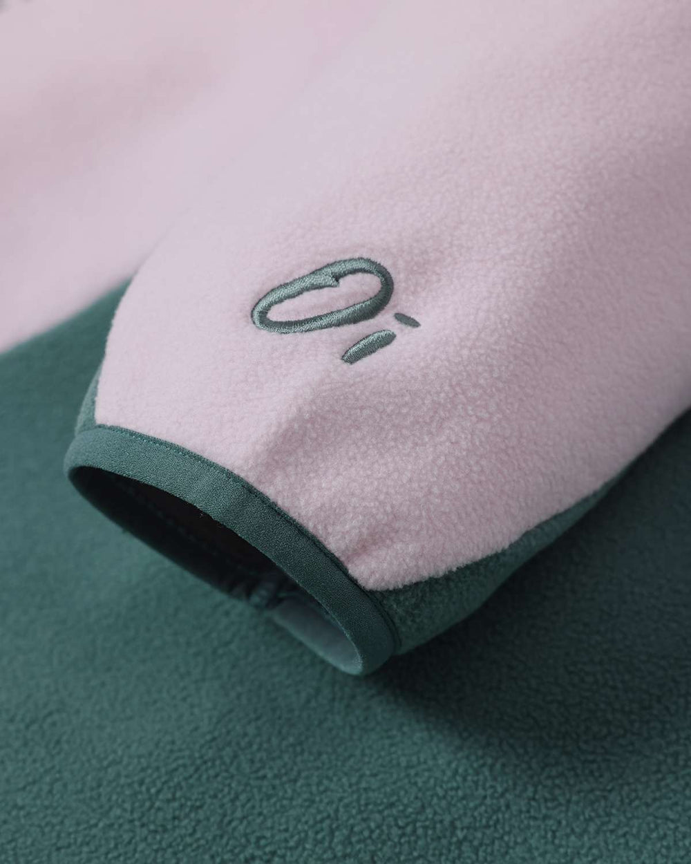 Fleece cuff with small embroidered icon and folded edge in green and pink