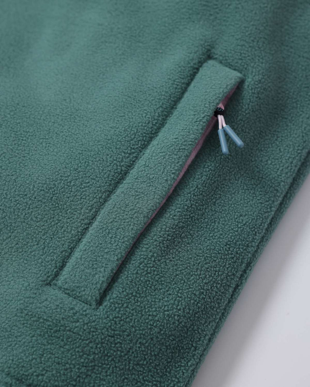 Green fleece jacket sleeve hem with side seam and small stitched slit detail