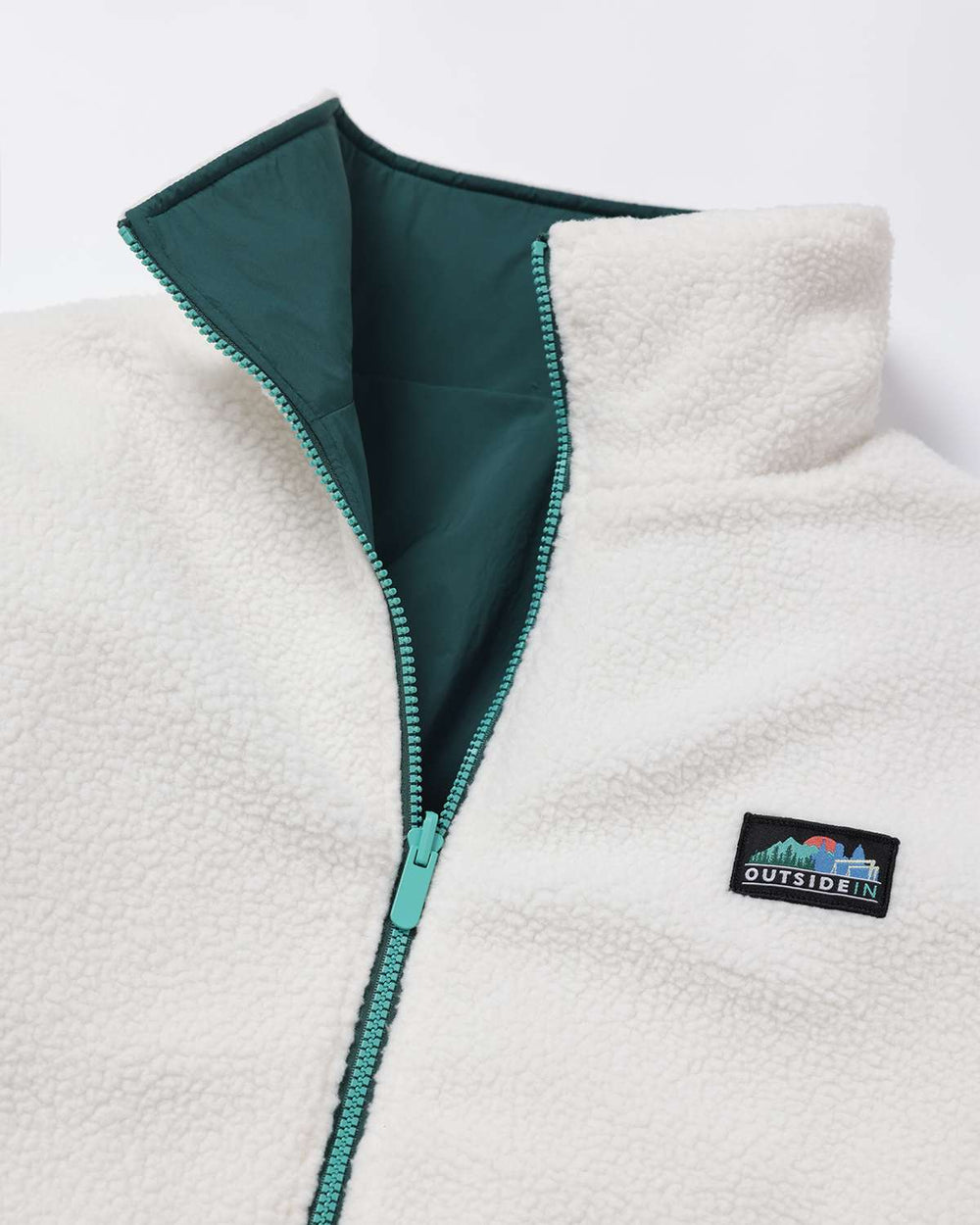 Reversible fleece jacket with teal inner side and white sherpa outer, zip front