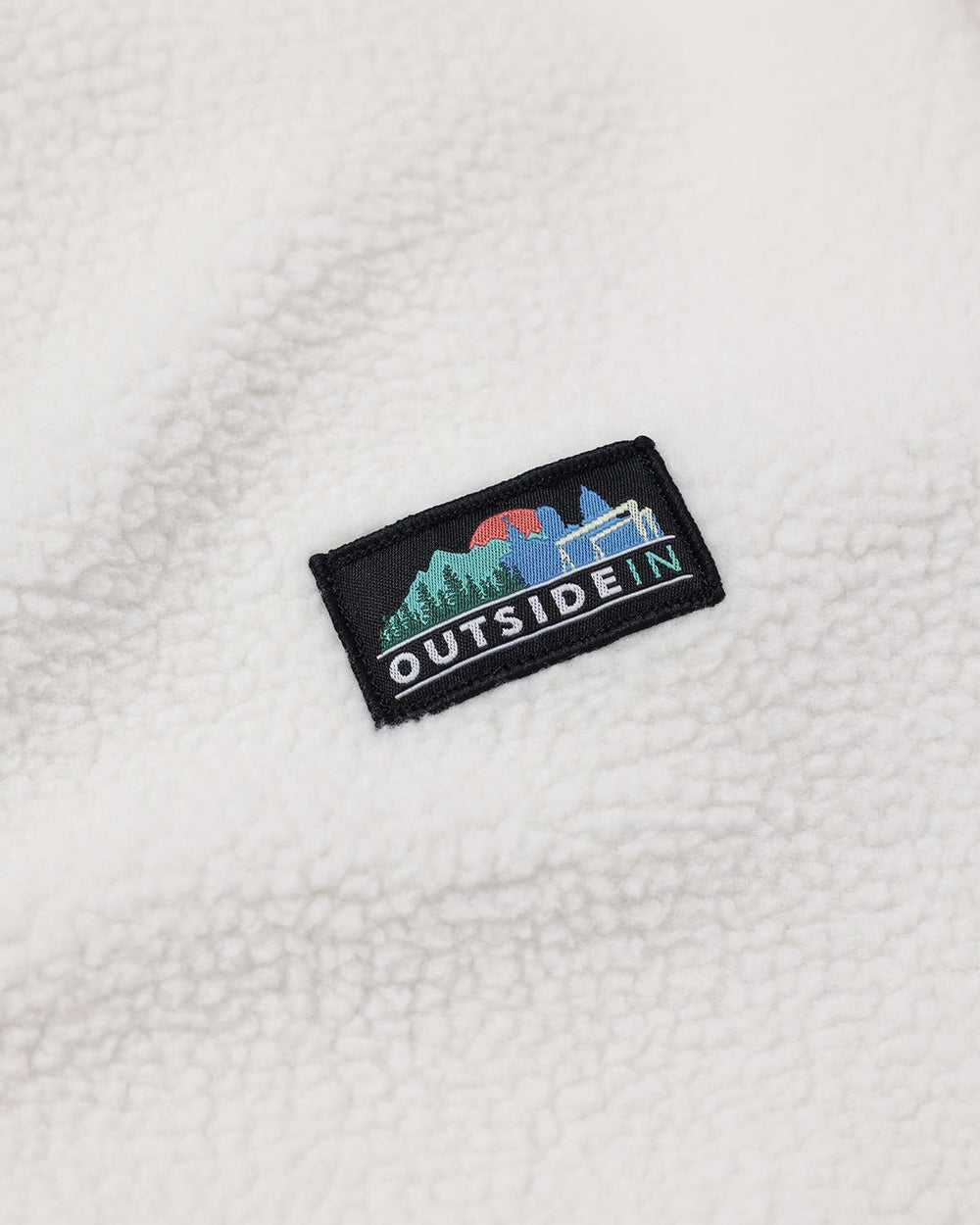 White sherpa fleece jacket with OutsideIn logo patch on chest