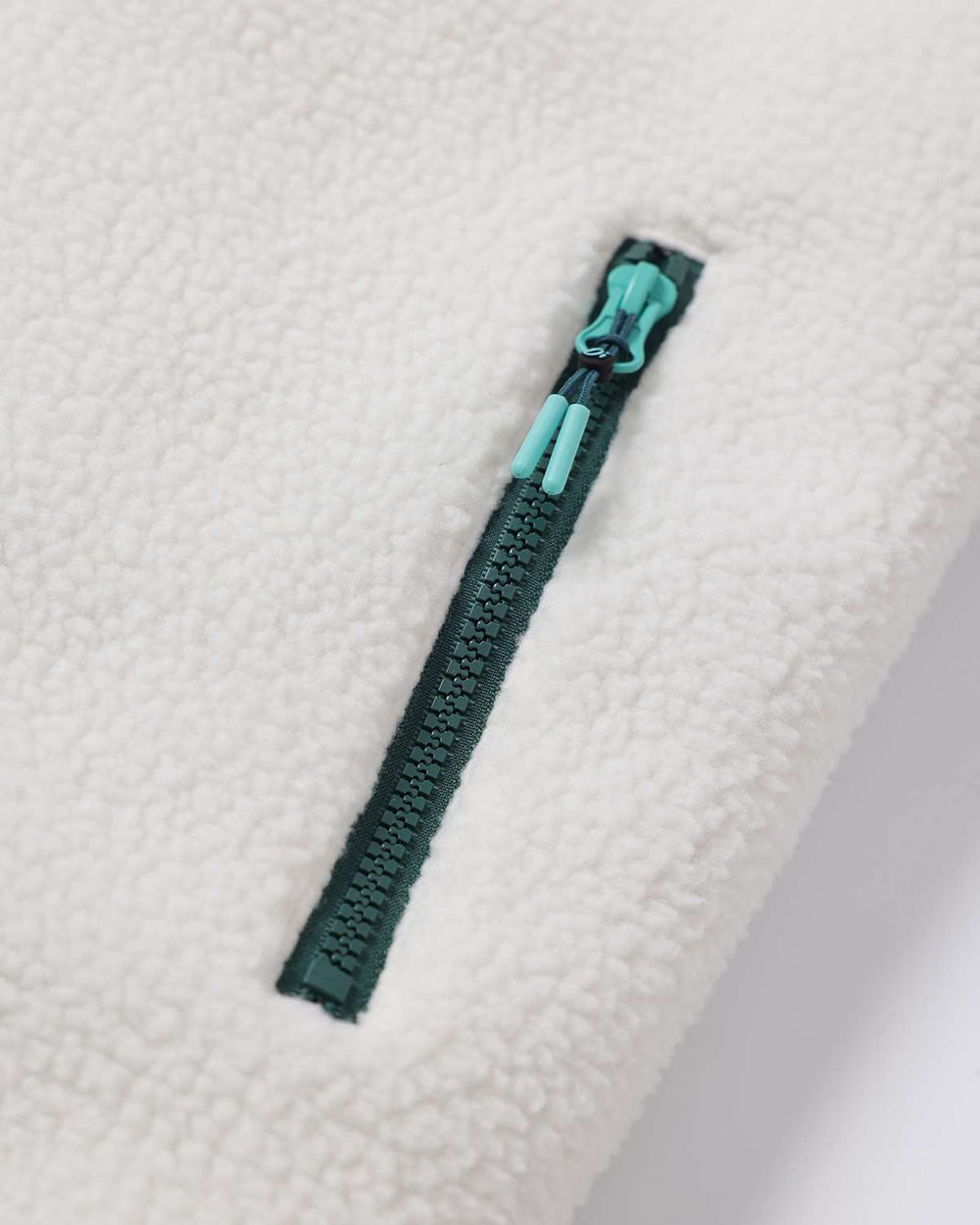 White sherpa fleece jacket with teal zipper and pull tab