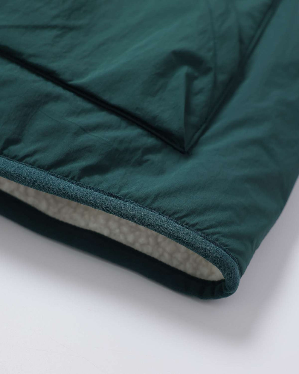 Dark teal jacket hem detail with fleece lining at the edge