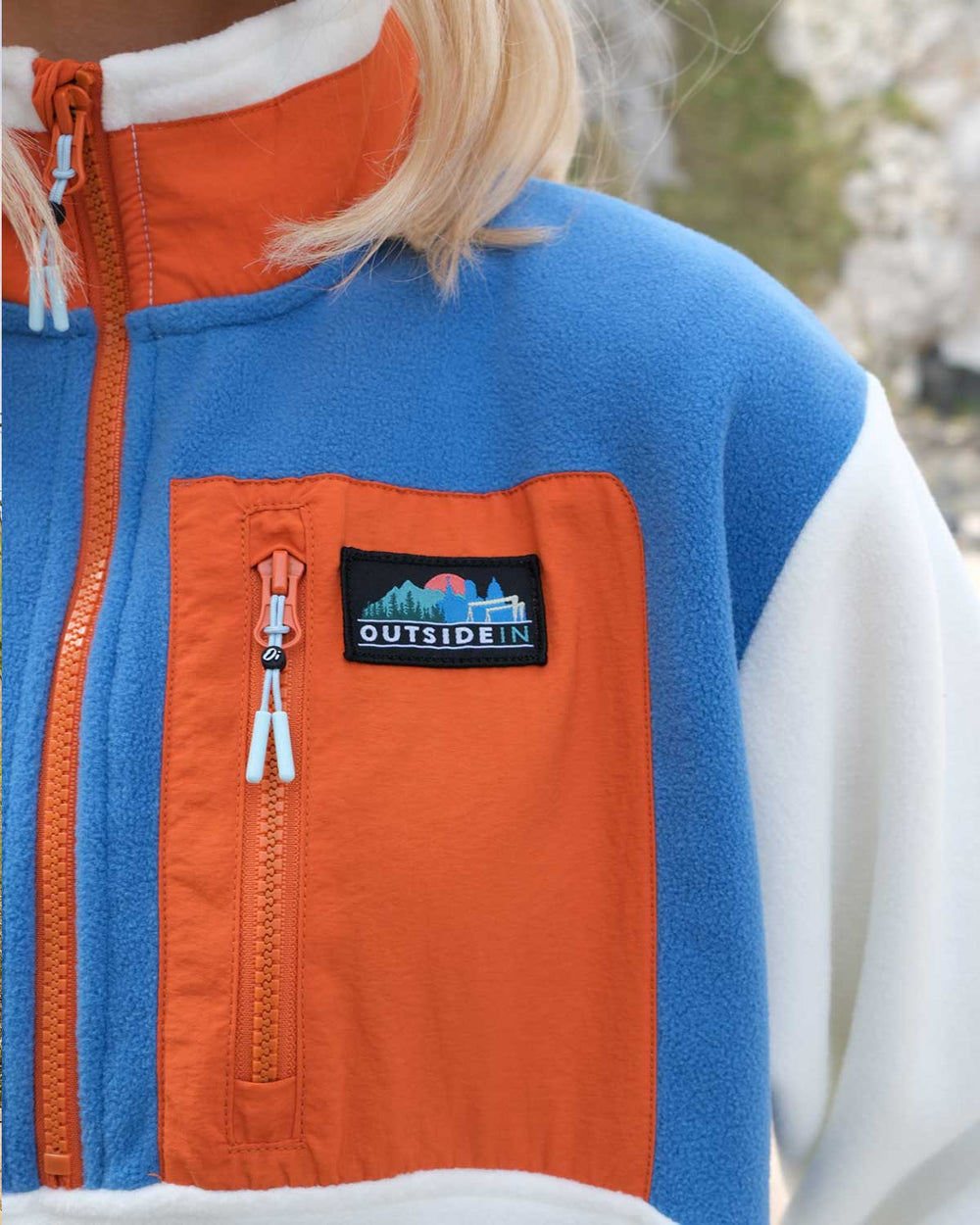 Close up of OutsideIn Blue & Orange Signature Pocket Fleece