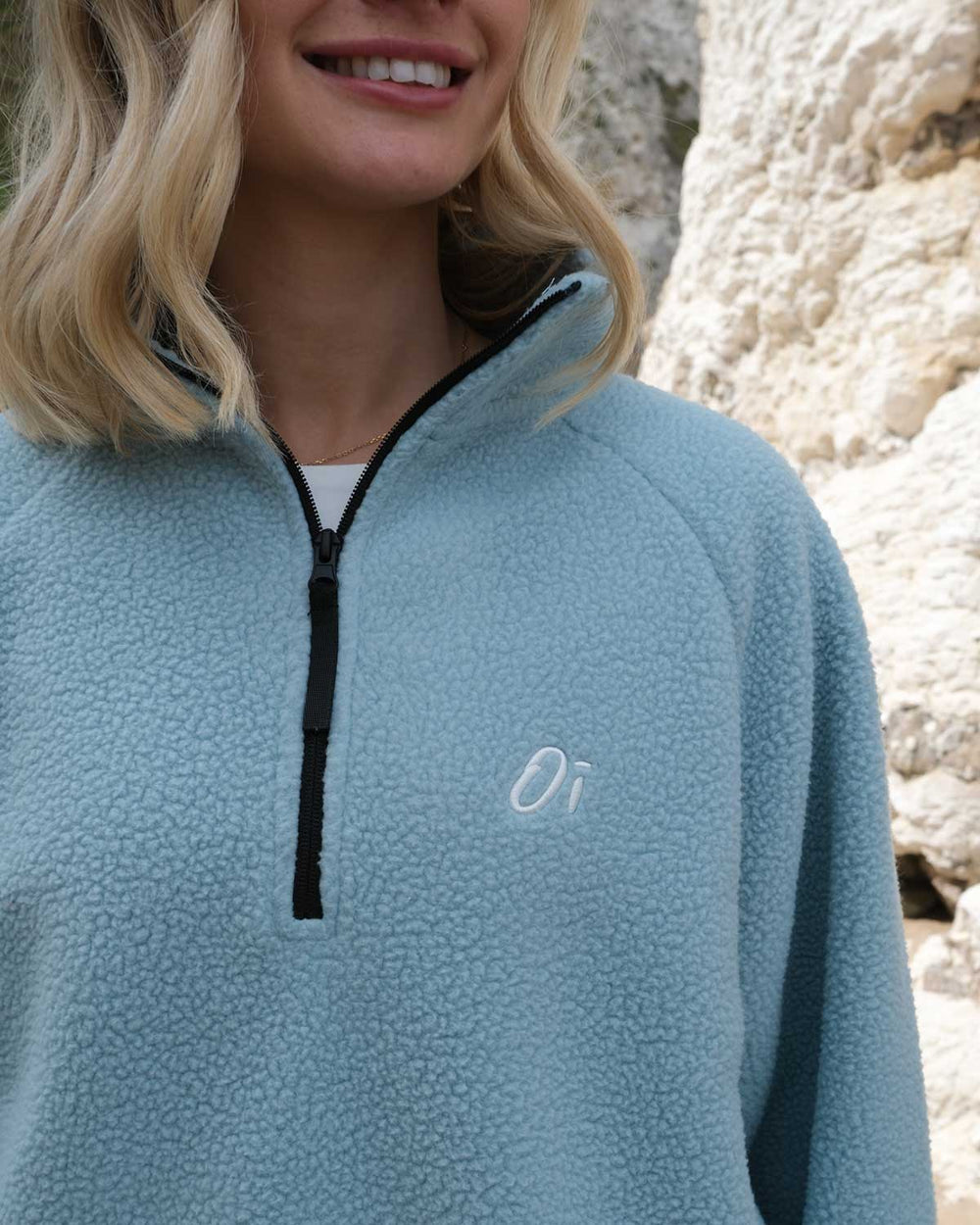 Close up of OutsideIn Blue Teddy Essential Fleece logo