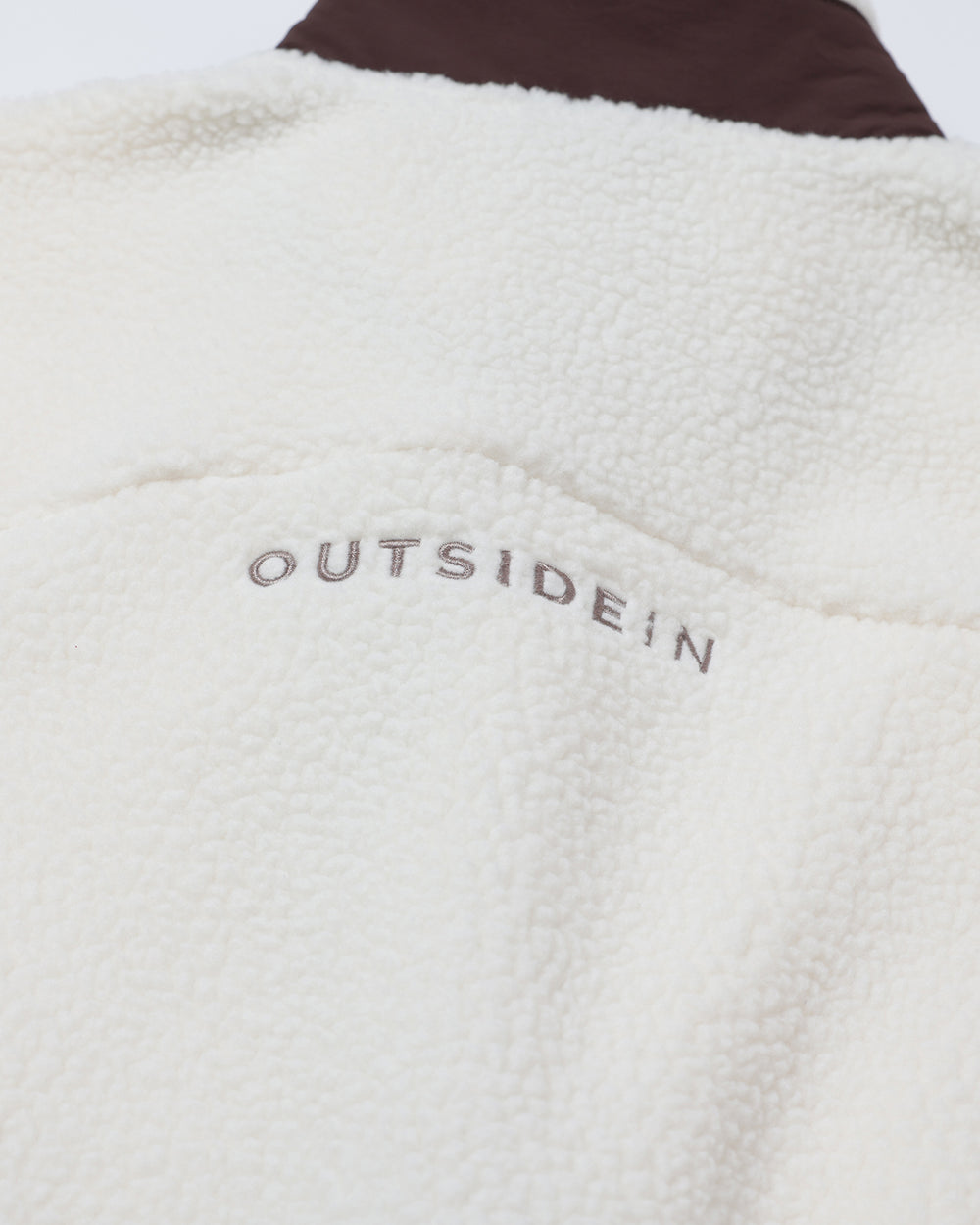 Close-up of a textured fabric with 'OUTSIDEIN' branding.