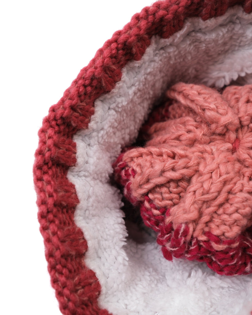Pom hat in Coral Reef colour with classic cable knit pattern and partial fleece base lining