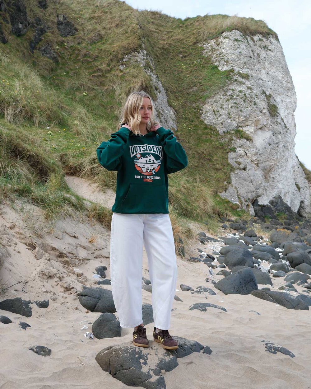 Model wearing green OutsideIn For The Outsiders Hoodie 
