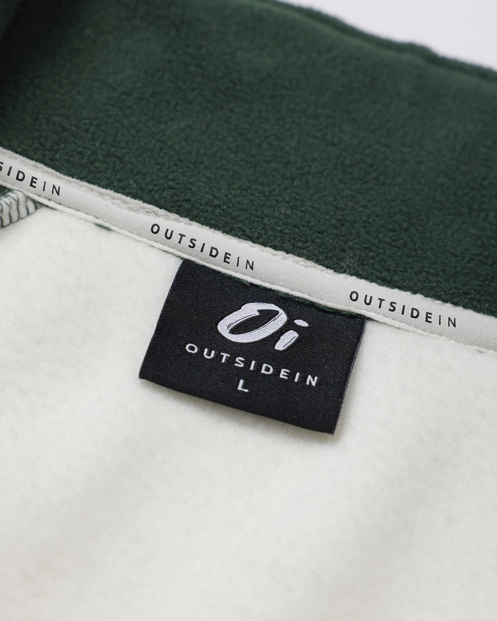 Close-up of a OutsideIn neck label on flat lay white background.