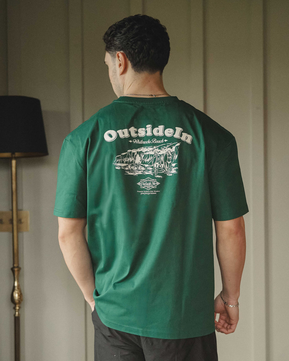 Model wearing a green t-shirt with 'OutsideIn' Whiterocks graphic.