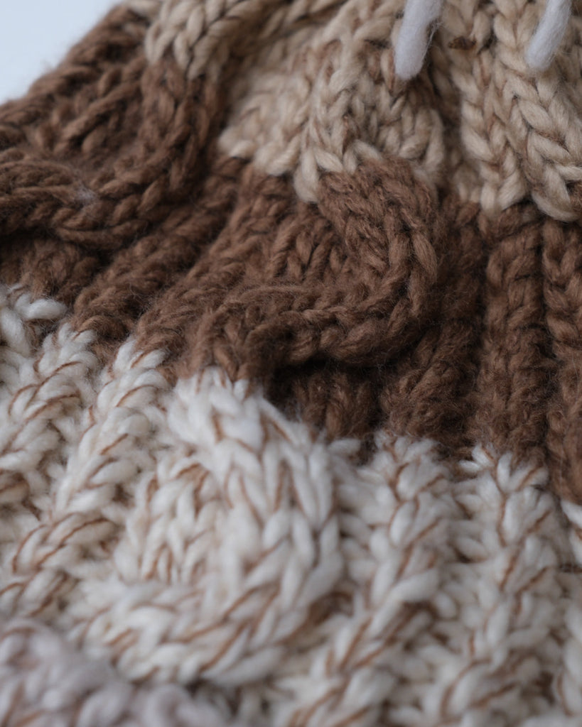 Pom hat in hazelnut swirl colour with classic cable knit pattern and partial fleece base lining