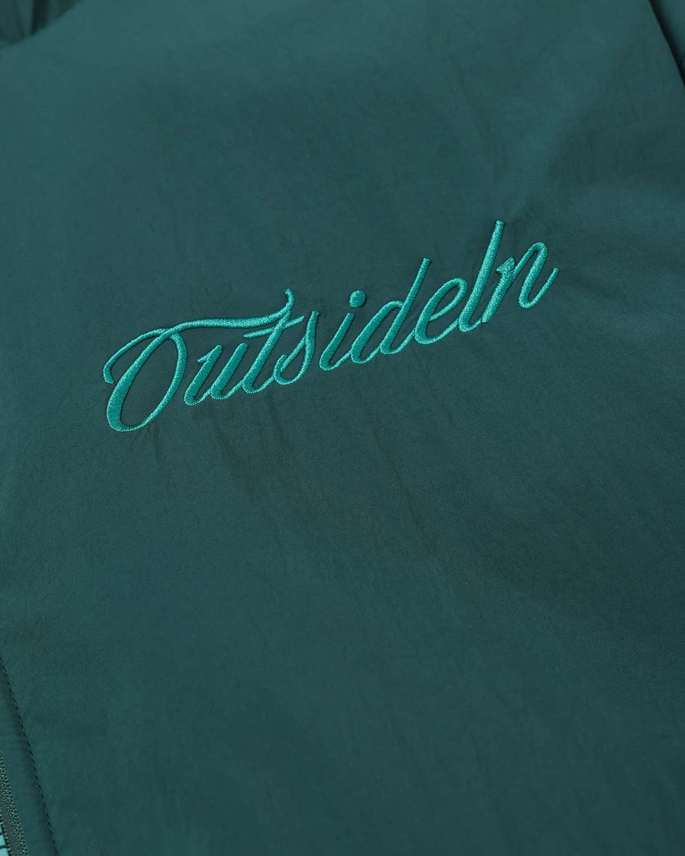 Dark teal jacket front with teal embroidered logo across the chest
