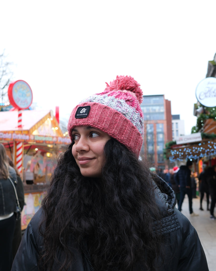 Pom hat in Coral Reef colour with classic cable knit pattern and partial fleece base lining