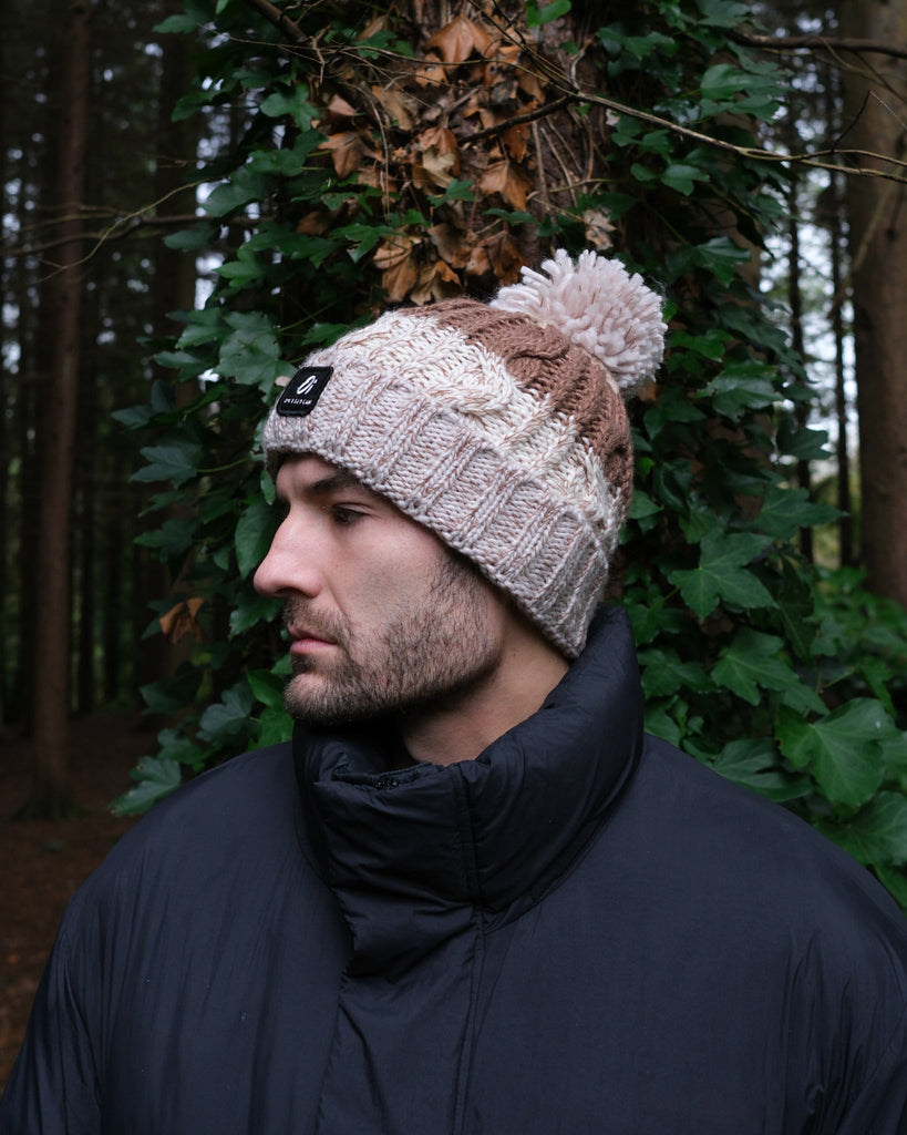 Pom hat in hazelnut swirl colour with classic cable knit pattern and partial fleece base lining