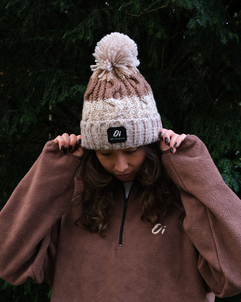 Pom hat in hazelnut swirl colour with classic cable knit pattern and partial fleece base lining