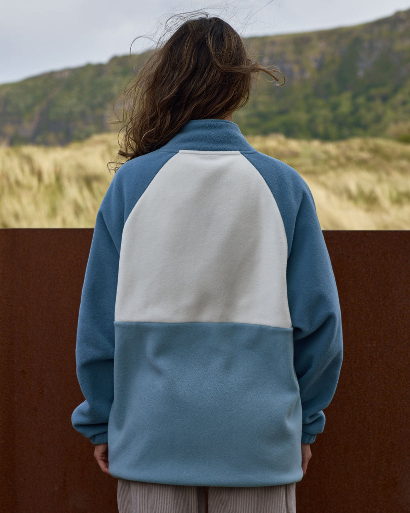 Unisex teal cream fleece with quarter zip, front pocket and toggle detail