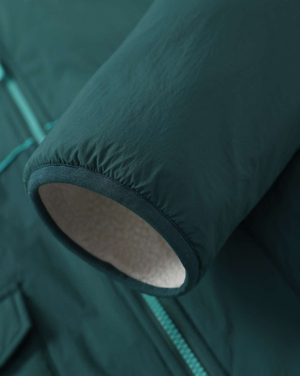 Dark teal jacket sleeve cuff with fleece-lined inner hem opening