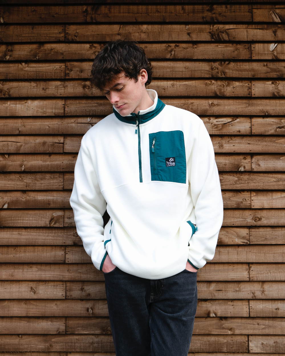 Model wearing outsideIn cream & pine green unisex fleece